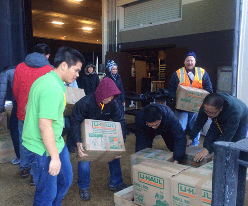 Các tình nguyện viên hồ hởi chuyển sách lên xe vận tải, sẵn sàng cho chuyến tàu đưa sách về Việt Nam. ảnh Dương Thư 